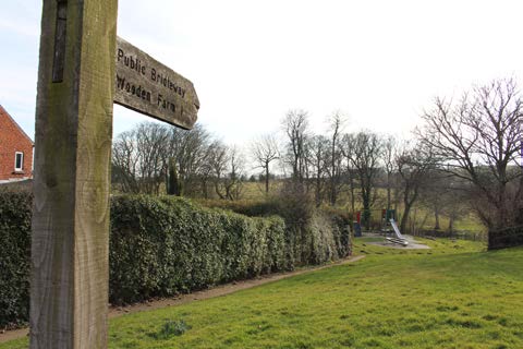 Wooden signpost pointing toward footpath on the Alnmouth Circular Walk