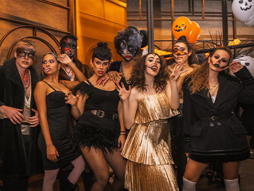 A group of 20-30 year olds wearing fancy-dress with their faces painted for Halloween.