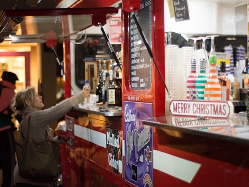 Woman getting a drink at a Christmas market stall