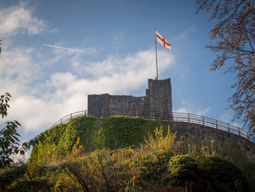 Clitheroe Castle on top of a hill with its flag pole clear against the blue sky