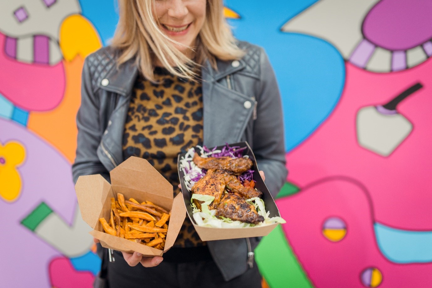 Image of a woman holding street food in takeaway containers