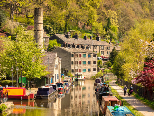 The canal at Hebden Bridge with canal boats lining the edges.