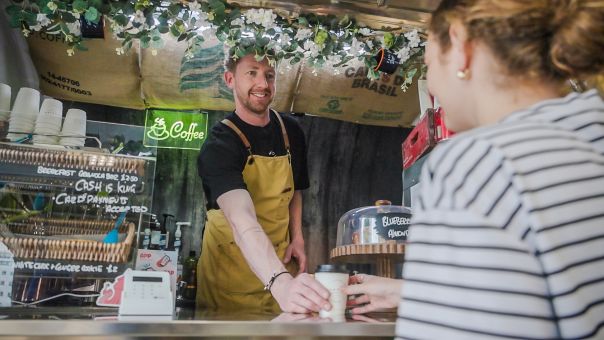 Owner of Jam Bake giving coffee to customer