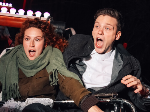 Two riders react in fear on a Halloween-themed amusement ride.