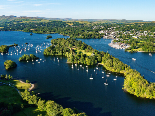 Lake Windermere from above with lots of boats dotted between the Lake's islands.