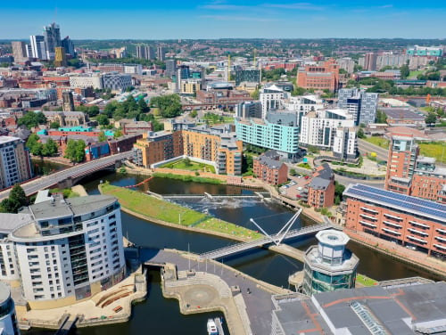 Aerial view of Leeds city centre, showing the River Aire, bridges and surrounding buildings.