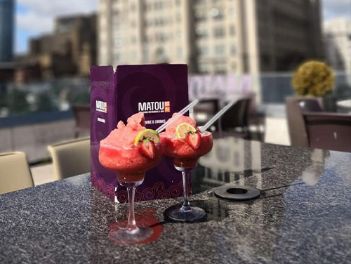 Two cocktails sitting on a table inside Matou rooftop bar in Liverpool