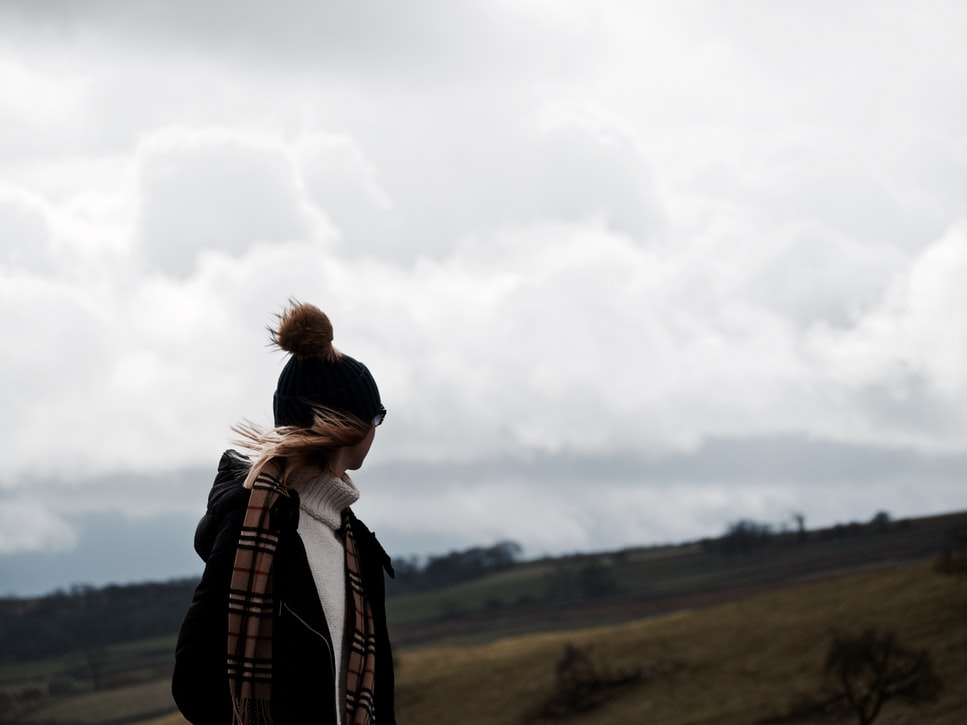 Windswept woman looking over the hills in Malham