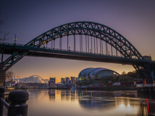 Newcastle Gateshead bridge at dusk with the last of the sun reflecting off the river tyne.