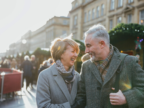 Older couple with coats on smiling at each other