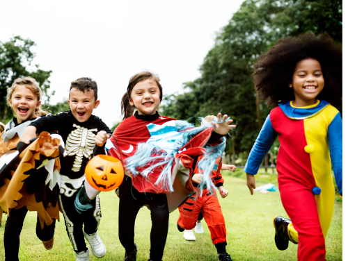 Small children dressed in Halloween costumes running towards the camera