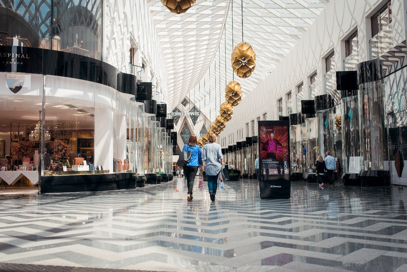 Image of two women walking through an indoor shopping centre