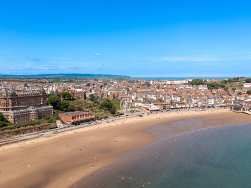 Scarborough beach from above with the promenade behind seen behind the beach.