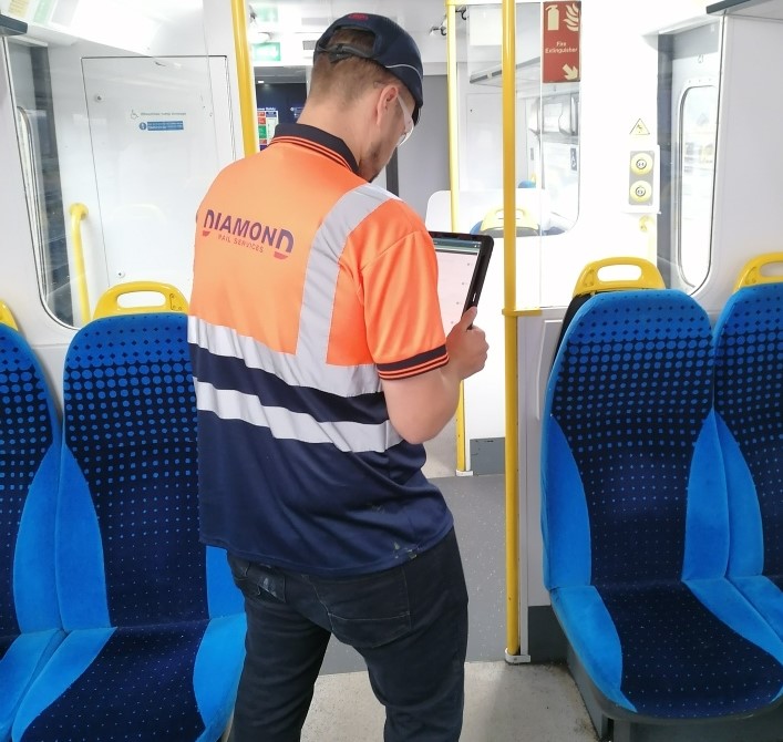 Photo of employee looking at the condition of train seat covers