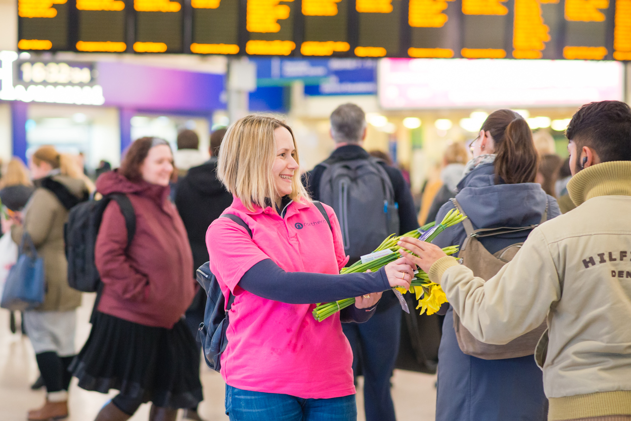 Experiential - Advertiser handing out daffodils to customers at a train station