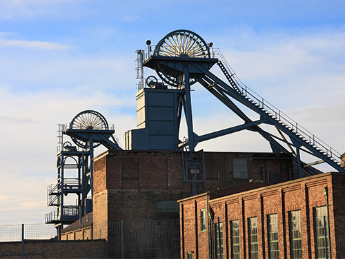 Woodhorn Museum's roof with mining equipment on top. There is a staircase going up to the wheel that sorts coal.