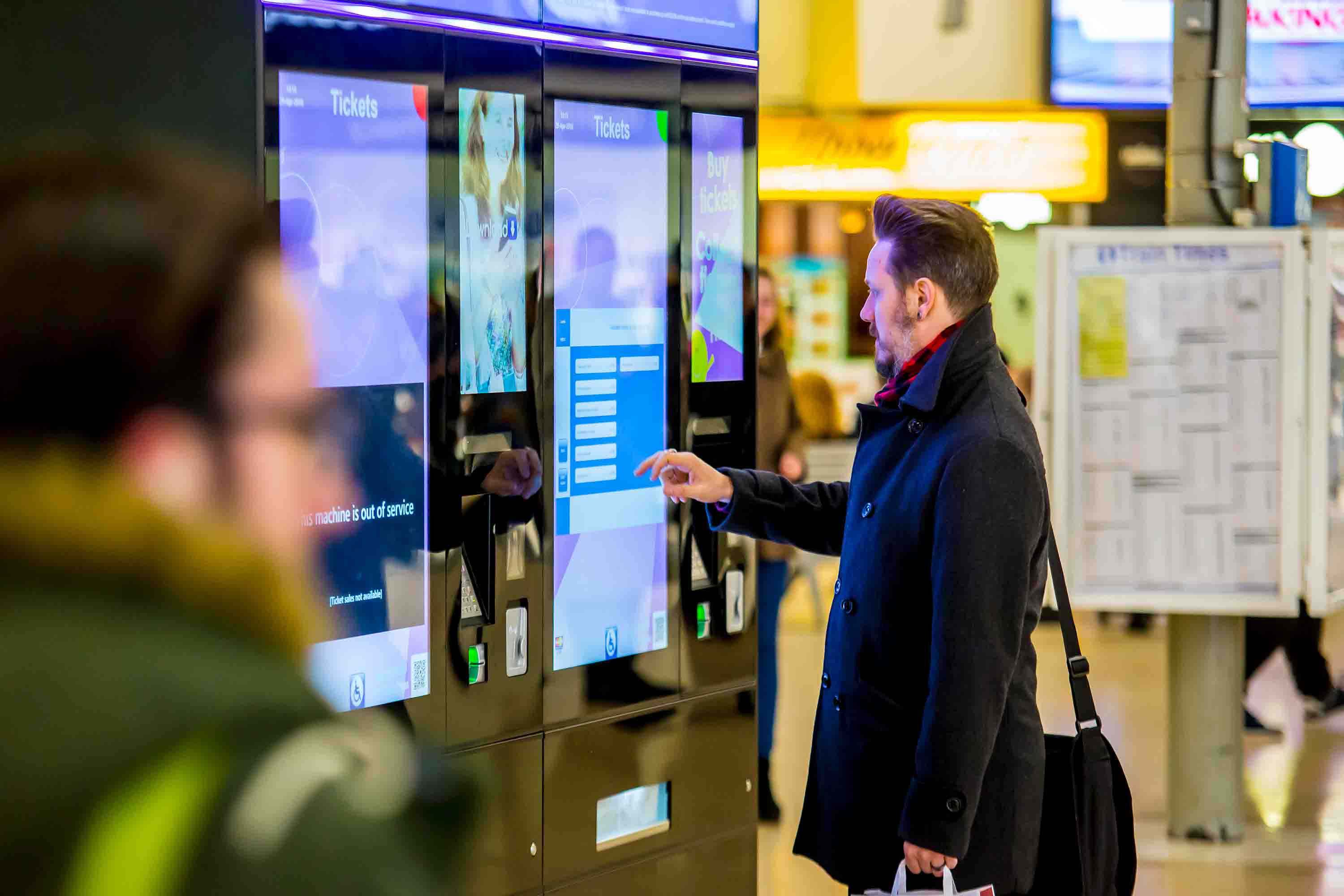 Customer using a ticket vending machine at a train station