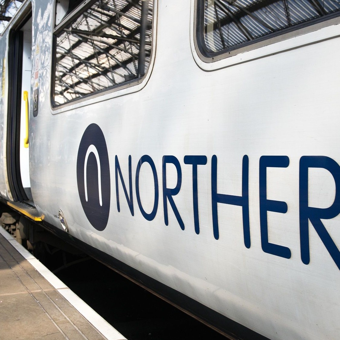 Image shows a Northern train on a platform cropped
