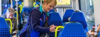 Image shows conductor performing on-board ticket checks image-shows-conductor-performing-on-board-ticket-checks