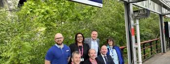 This image shows Northern and Bradford Childrens & Family Trust staff under the tempary signage for Bradford Foster Square which has been changed from Bradford Forster Square this-image-shows-northern-and-bradford-childrens-and-family-trust-staff-under-the-tempary-signage-for-bradford-foster-square-which-has-been-changed-from-bradford-forster-square