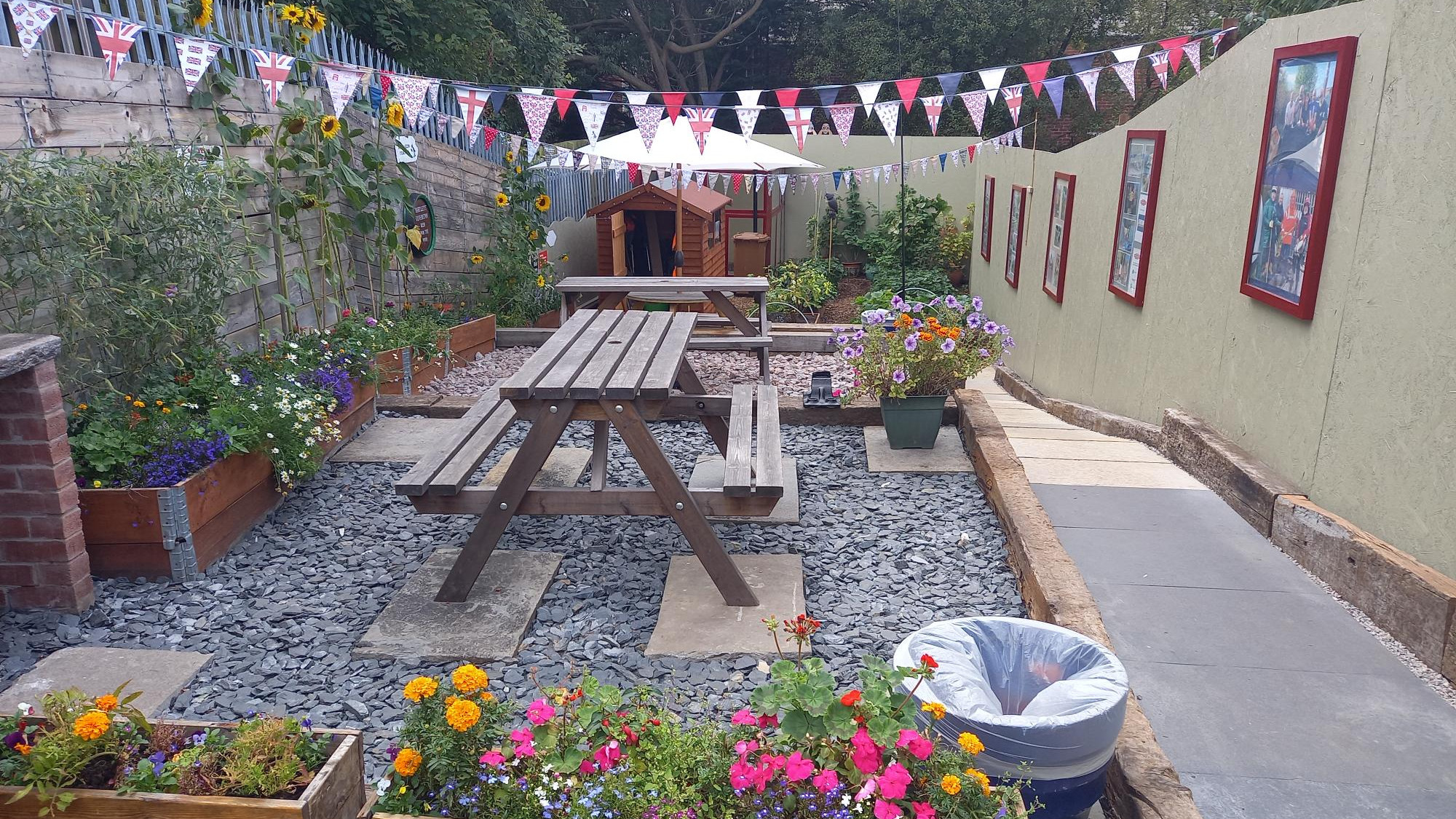 Barrow memorial garden with planters, a picnic bench and colourful flowers