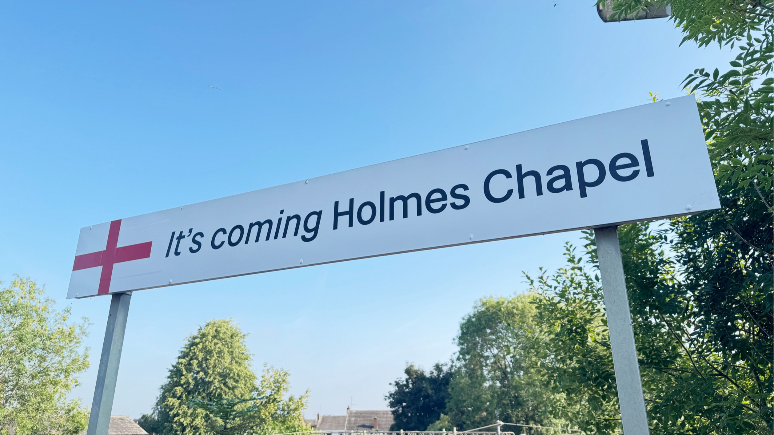 IT'S COMING HOLMES CHAPEL station sign
