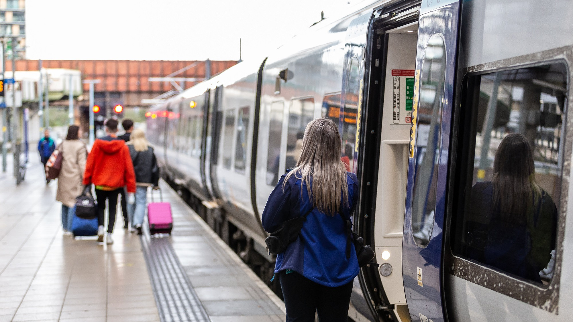 Image shows a family boarding a Northern train
