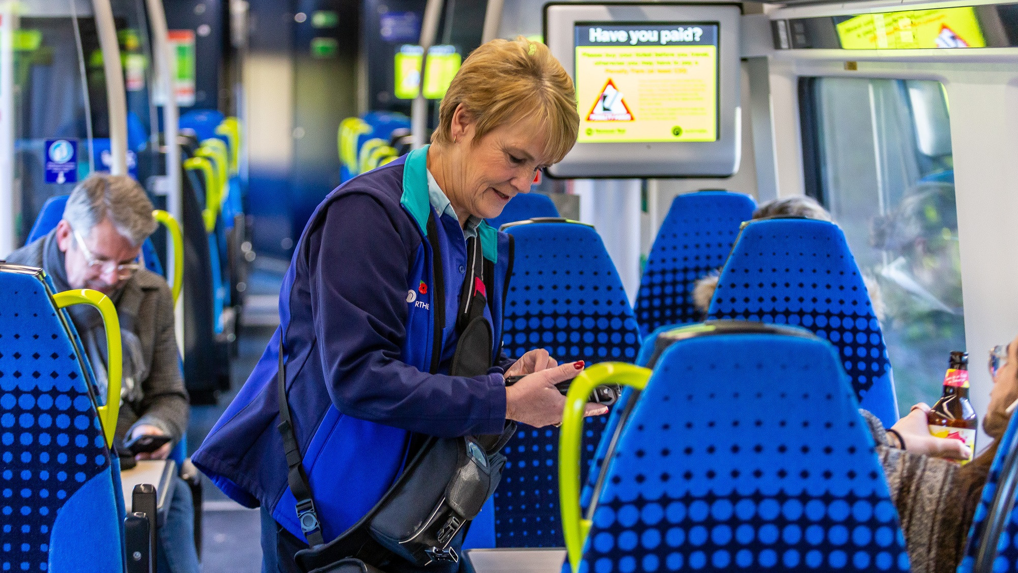 Image shows conductor performing on-board ticket checks