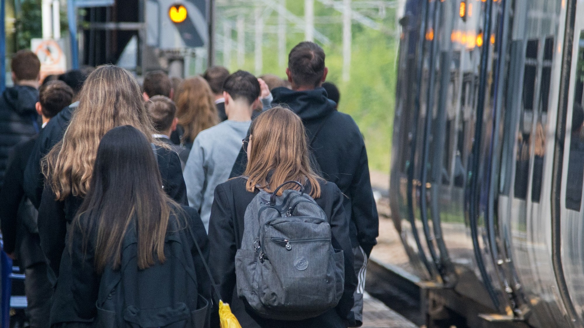 Image shows schoolchildren alongside a Northern train at a platform