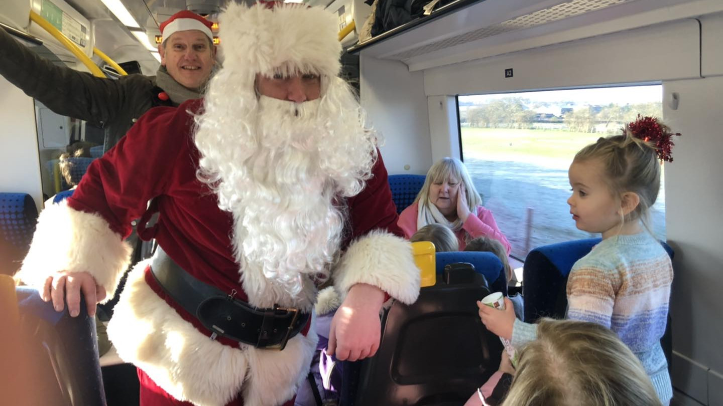 This image shows Father Christmas spreading festive cheer on a Northern train