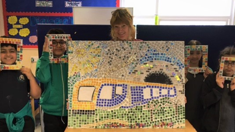 This image shows Frizinghall pupils with their train mosaic
