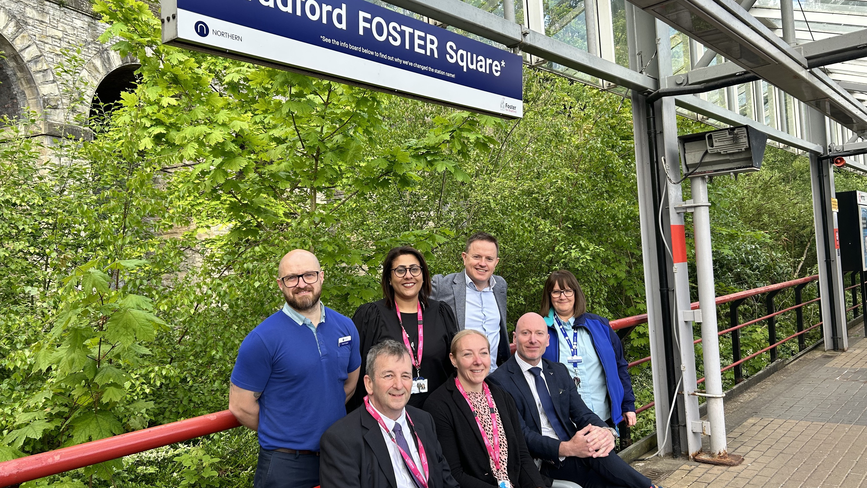 This image shows Northern and Bradford Childrens & Family Trust staff under the tempary signage for Bradford Foster Square which has been changed from Bradford Forster Square