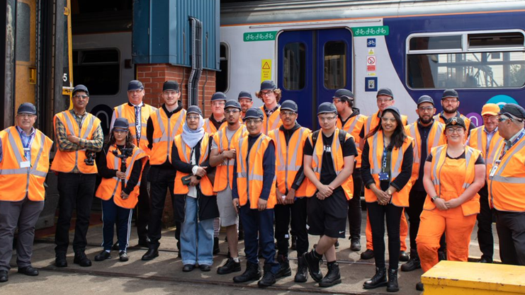 This image shows colleagues and students at Neville Hill depot in front of a Northern train
