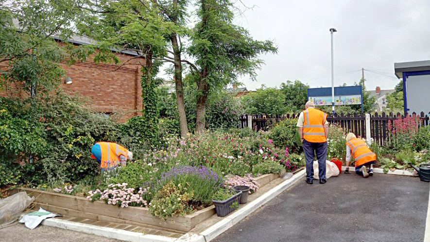 This image shows volunteers tending to flowebeds at one of Northern's stations
