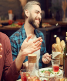 Image of people laughing and sharing food around a dinner table