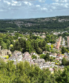 Looking down on a town from above, the sun is shining, and the houses are in neat rows.