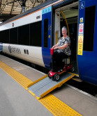 Woman on mobility scooter users train via ramp
