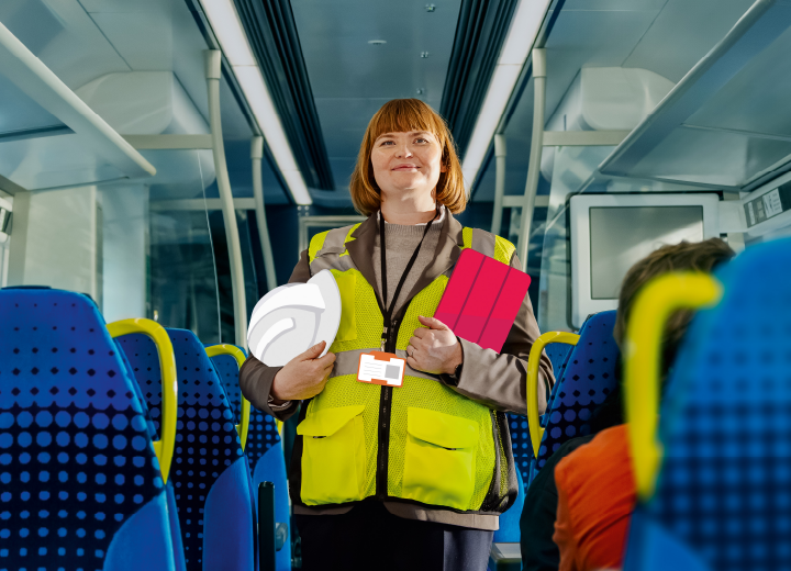 Construction worker on a train, holding her tablet and hat.